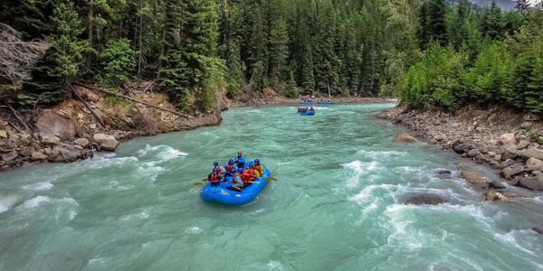 Adventurers enjoying an exhilarating white-water rafting experience in Banff, surrounded by the stunning Rocky Mountain scenery. A must-try activity on Western Canada Rockies Adventure Tours.