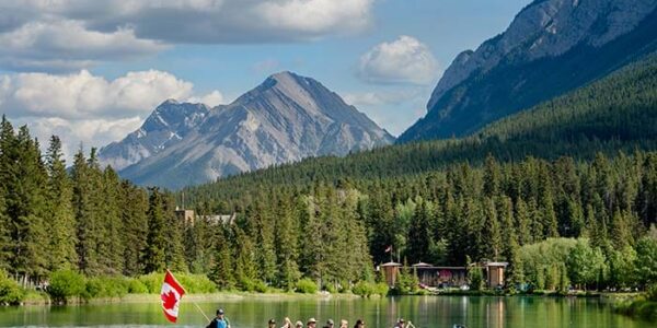 Passengers kayaking on a serene lake during the Western Canada Adventure Tour by Revelstoke